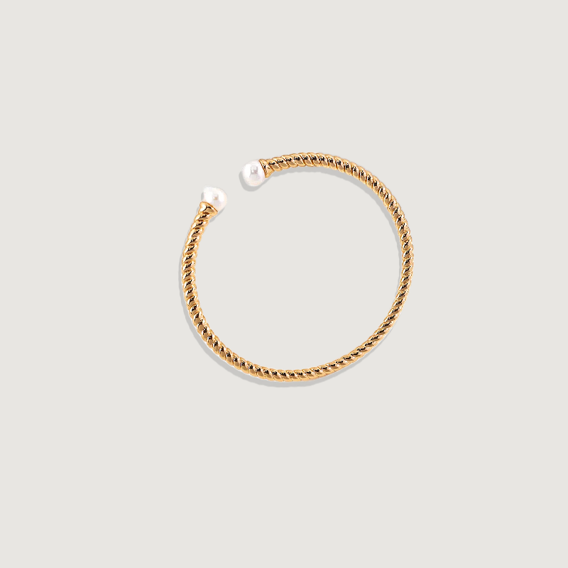 Luxurious gold bangle from Real Wo Jewellery adorned with a creamy pearl, highlighting refined craftsmanship and a minimalist, sophisticated design, to enhance personal integrity, promote truth, and provide a sense of calm and well-being.