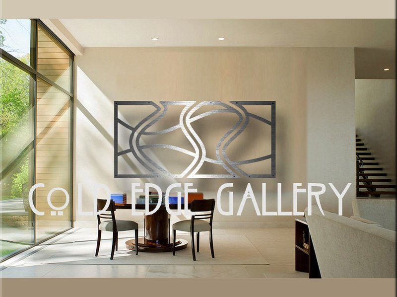 A modern gallery space featuring large abstract metal artwork on the wall, with natural light stream...