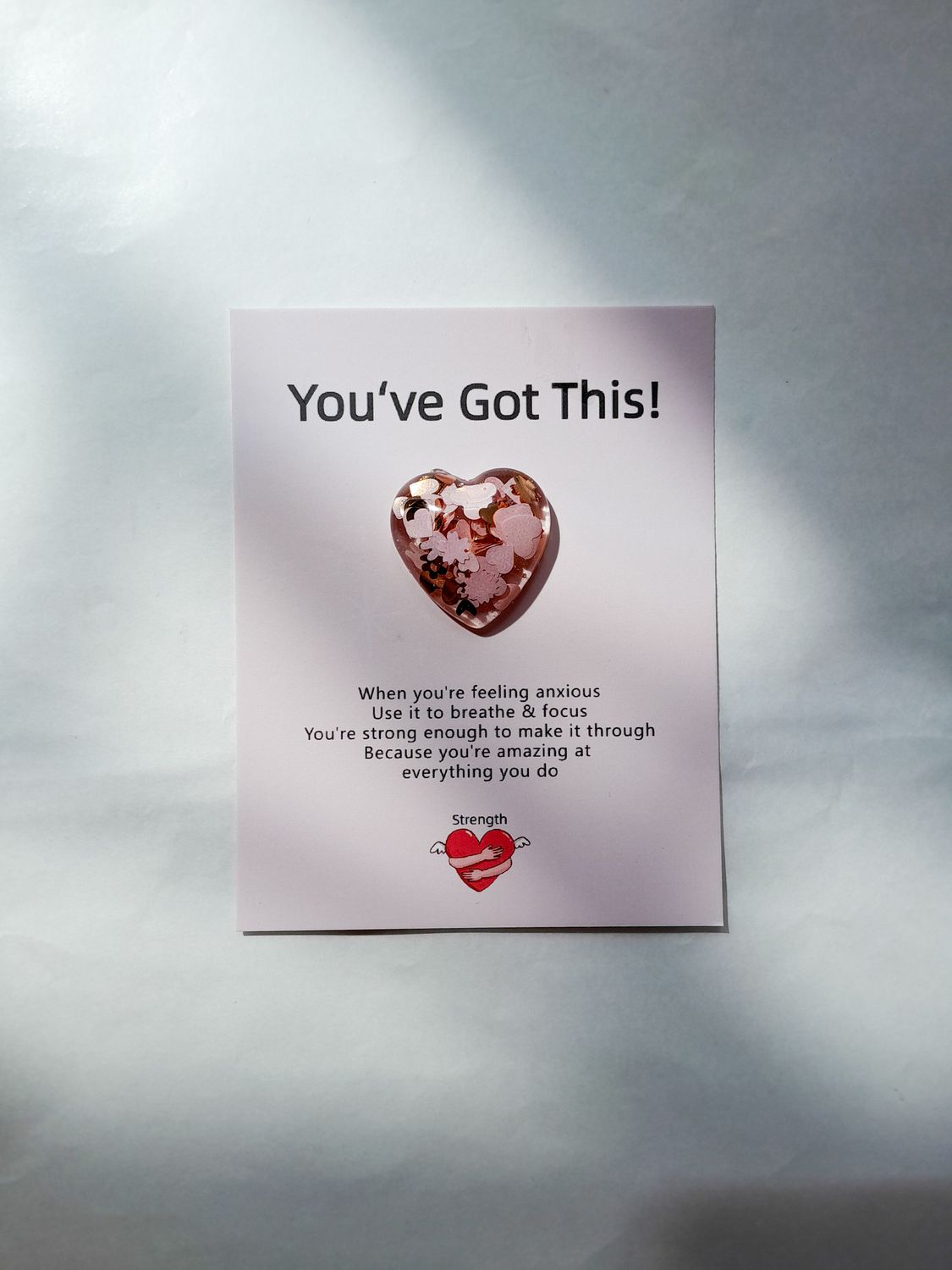 Heart-shaped resin keepsake with glitter and floral details, attached to a card reading “You’ve Got This!”