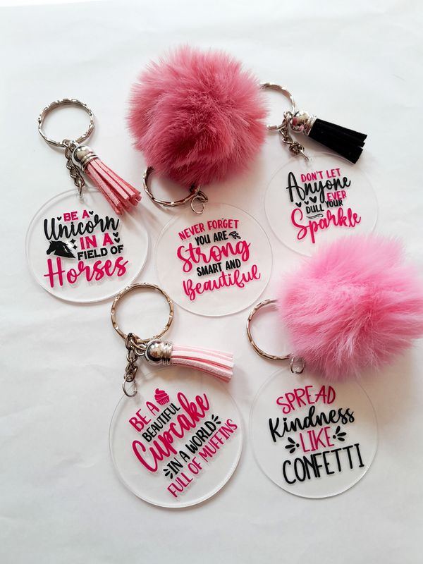 Set of five women empowerment acrylic keychains with tassels or pom-poms, each featuring an uplifting quote.