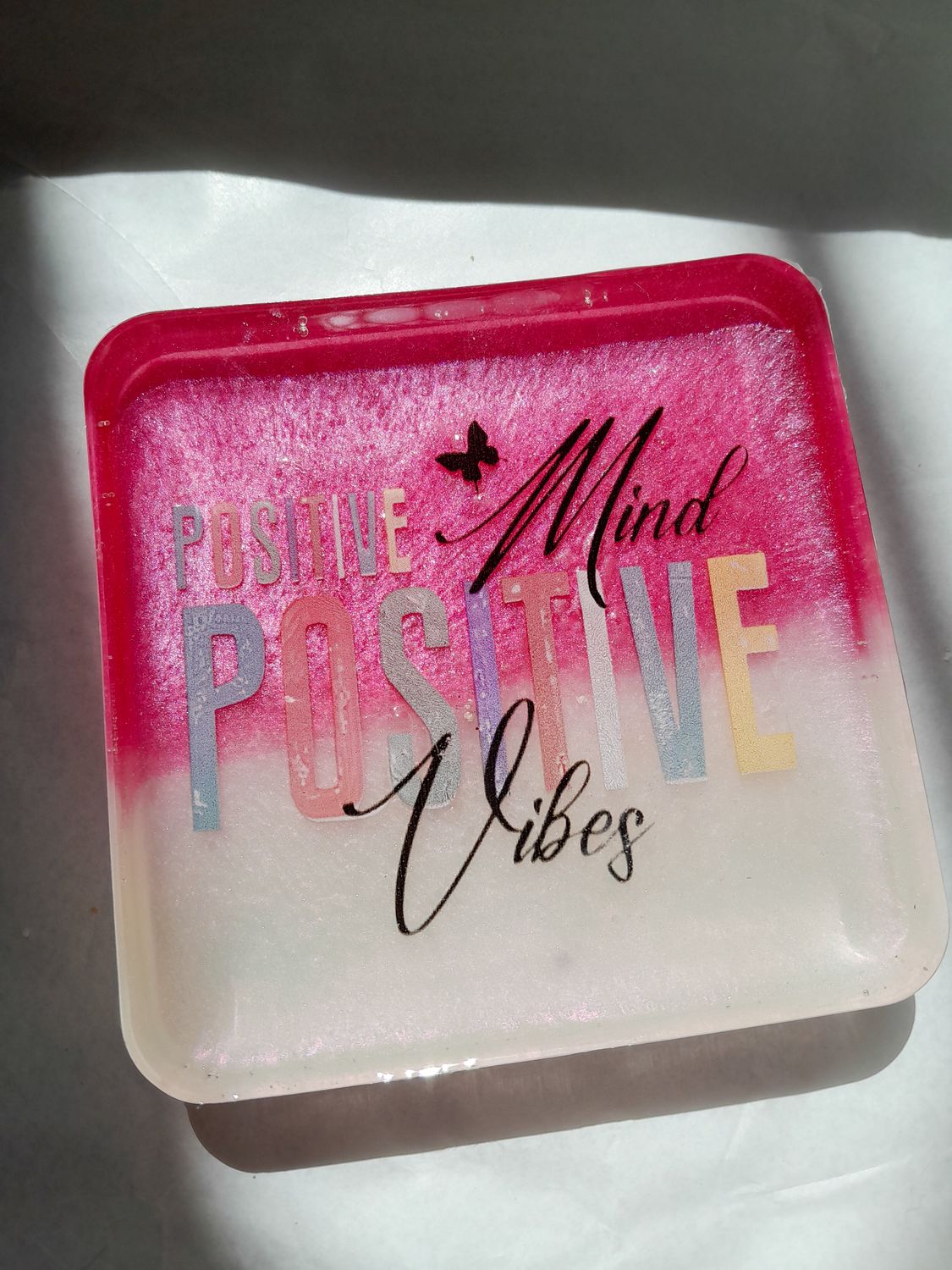 Resin desk stand in pink and white with the inspirational quote “Positive Mind, Positive Vibes”.