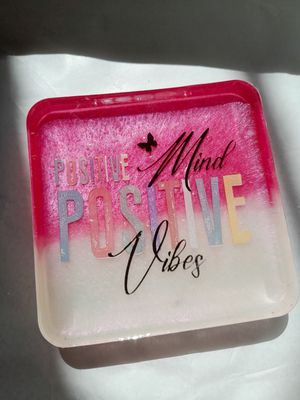 Resin desk stand in pink and white with the inspirational quote “Positive Mind, Positive Vibes”.