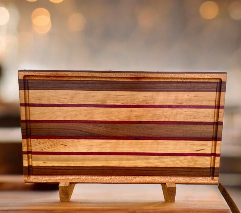 Planche à découper en bois de Frêne et de Noyer. Avec insertions en bois de (Mahogany, Padauk et Purpleheart -bois exotiques-. Fait en côtés de planches (edge grain).