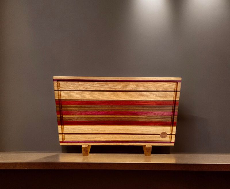 Planche à découper en bois de Frêne et de Noyer. Avec insertions en bois de Padauk et Purpleheart -bois exotiques-. Fait en côtés de planches (edge grain).