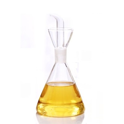 Glass cruet with spout, partially filled with oil