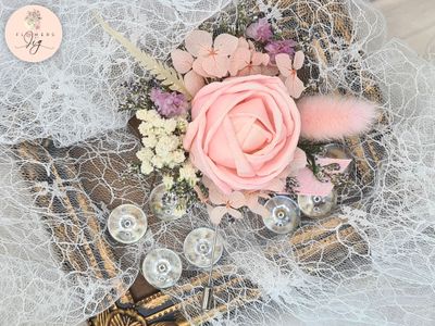 Experience timeless elegance with our Handcrafted Pink Rose Sola Wood Corsage/Boutonniere. Accented with dried caspia, gypsophila, meadow grass, and pink &amp; white ribbons, this piece is ideal for weddings, proms, or any special event