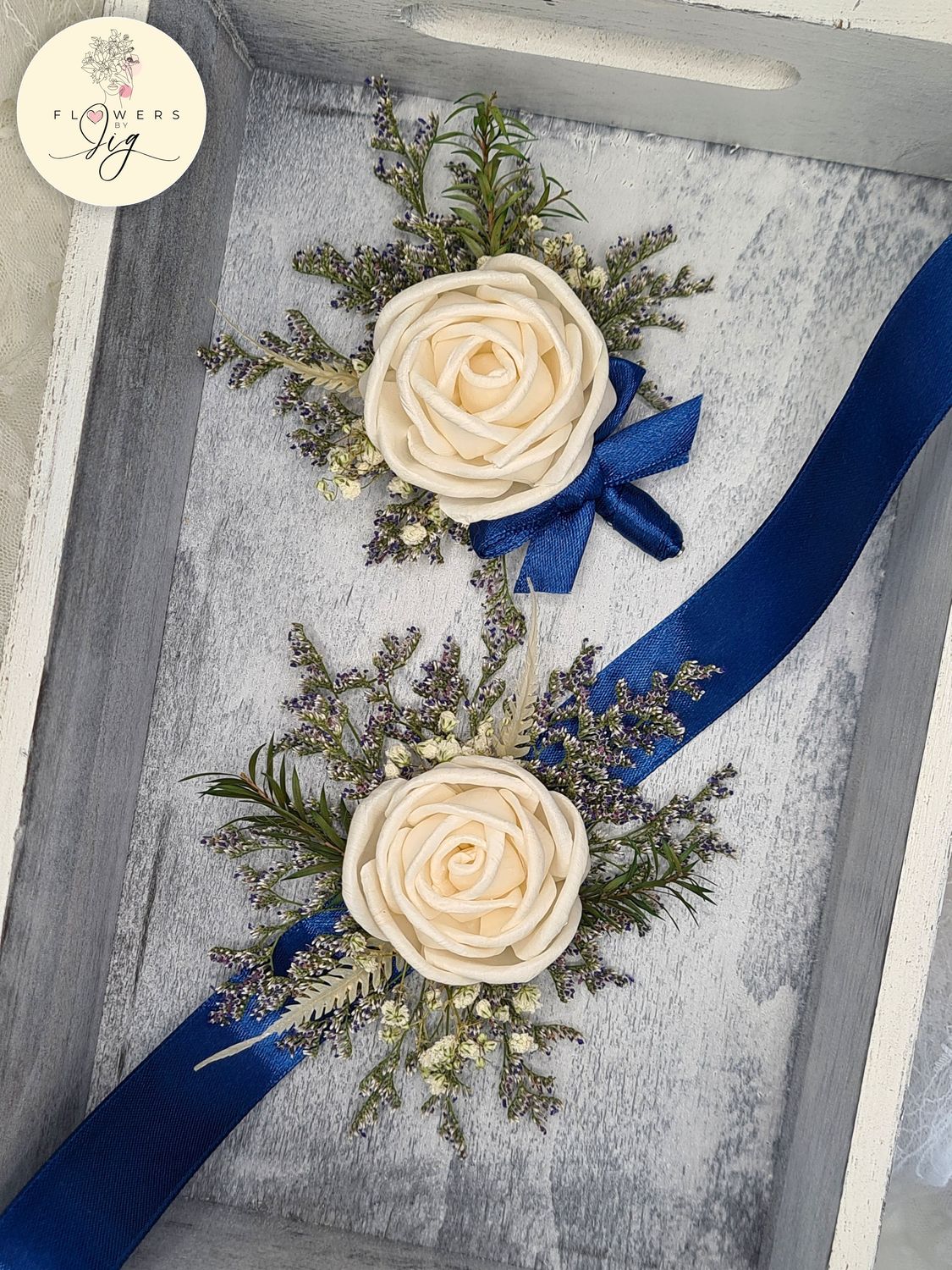 Crème Rose Sola Wood Corsage or Boutonnière, handcrafted with dried flowers, including Gypsophilia and iris. Eco-friendly, durable, and versatile, perfect for weddings, proms, or special events. Paired with a royal blue satin ribbon. Size: 4.5 inches