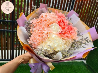 Elegant white sola wood rose bouquet featuring dried pink hydrangea, peach blooms, and caspia. Handcrafted floral arrangement perfect for weddings and celebrations. Long-lasting and beautifully presented.