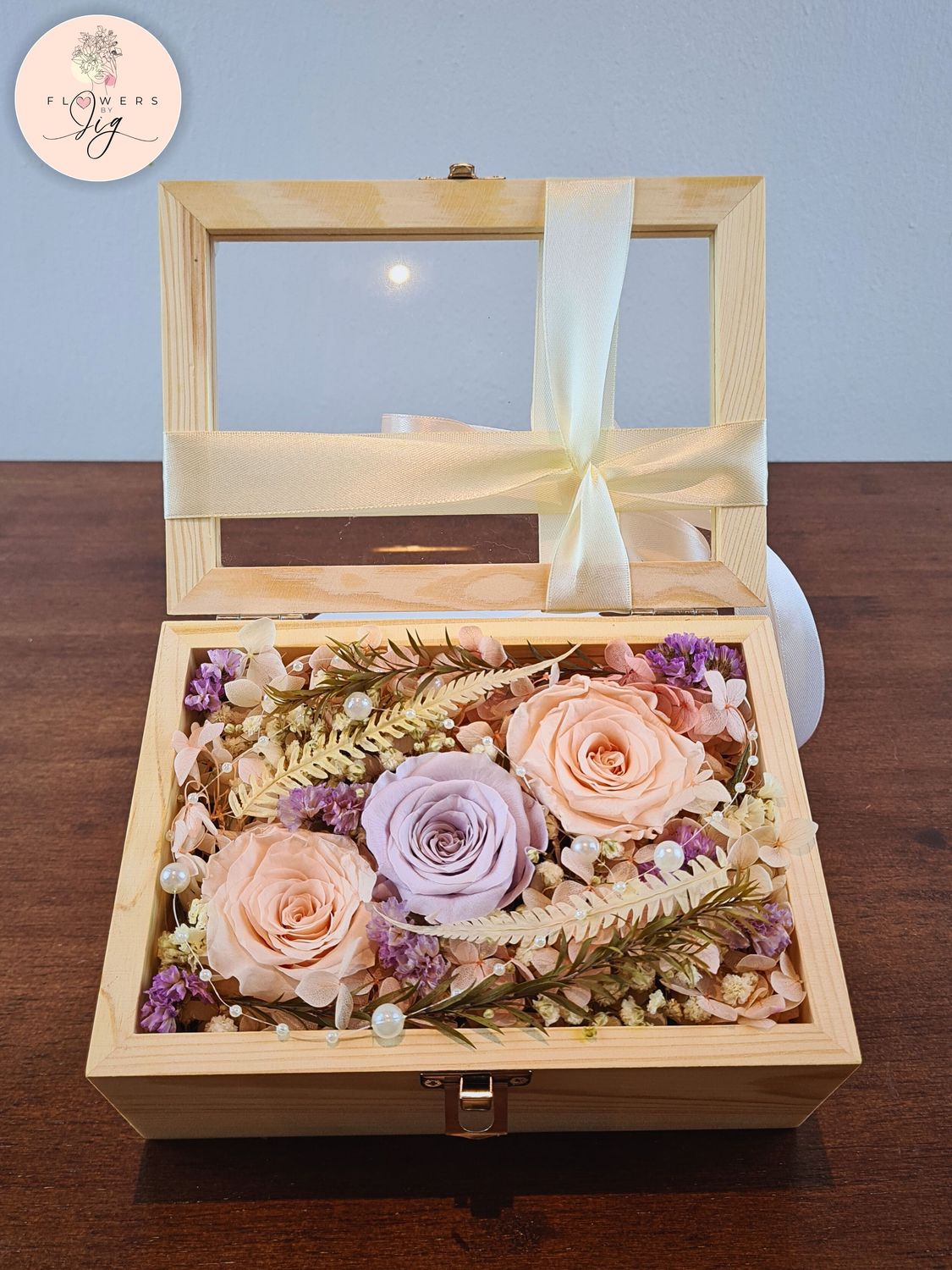 Pinewood Box with 2 Champagne Infinity Roses, 1 Vintage Purple Infinity Rose, and dried flowers. Includes decorative pearls and ferns. Perfect for anniversaries, weddings, and birthdays. Customizable glass box with luxurious satin ribbon