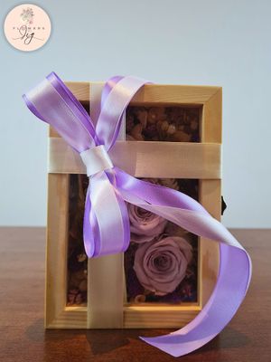 Our Glass Box Bouquet showcases 3 Vintage Purple Infinity Roses and dried flowers, elegantly arranged with ferns and pearls in a Pinewood box. Ideal for any occasion, this preserved rose arrangement offers customizable beauty and lasting charm.