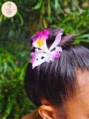 Realistic Pink Cattleya Orchid Hair Pin, hand-crafted from flexible polymer clay. Features a lifelike floral design in pink, white, and yellow, perfect for adding elegance to bridal or evening wear