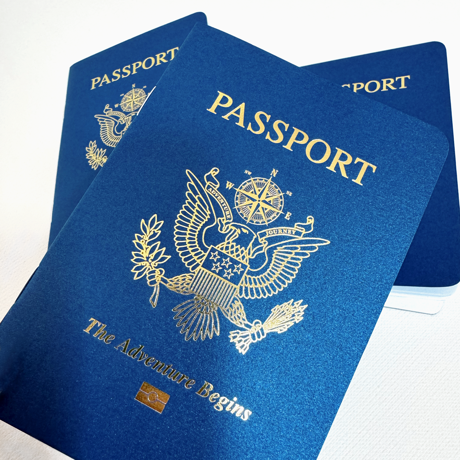 Alternate angle showing the blue and gold novelty passport booklets that are perfect to use as unique and creative party favors for a travel theme party or destination wedding.