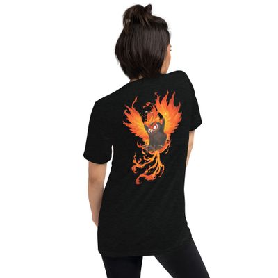 Black unisex t-shirt modeled by a woman, showcasing a striking design of a fiery owl with flaming wings in vibrant orange and red tones, symbolizing power and energy, by Aphodis.
