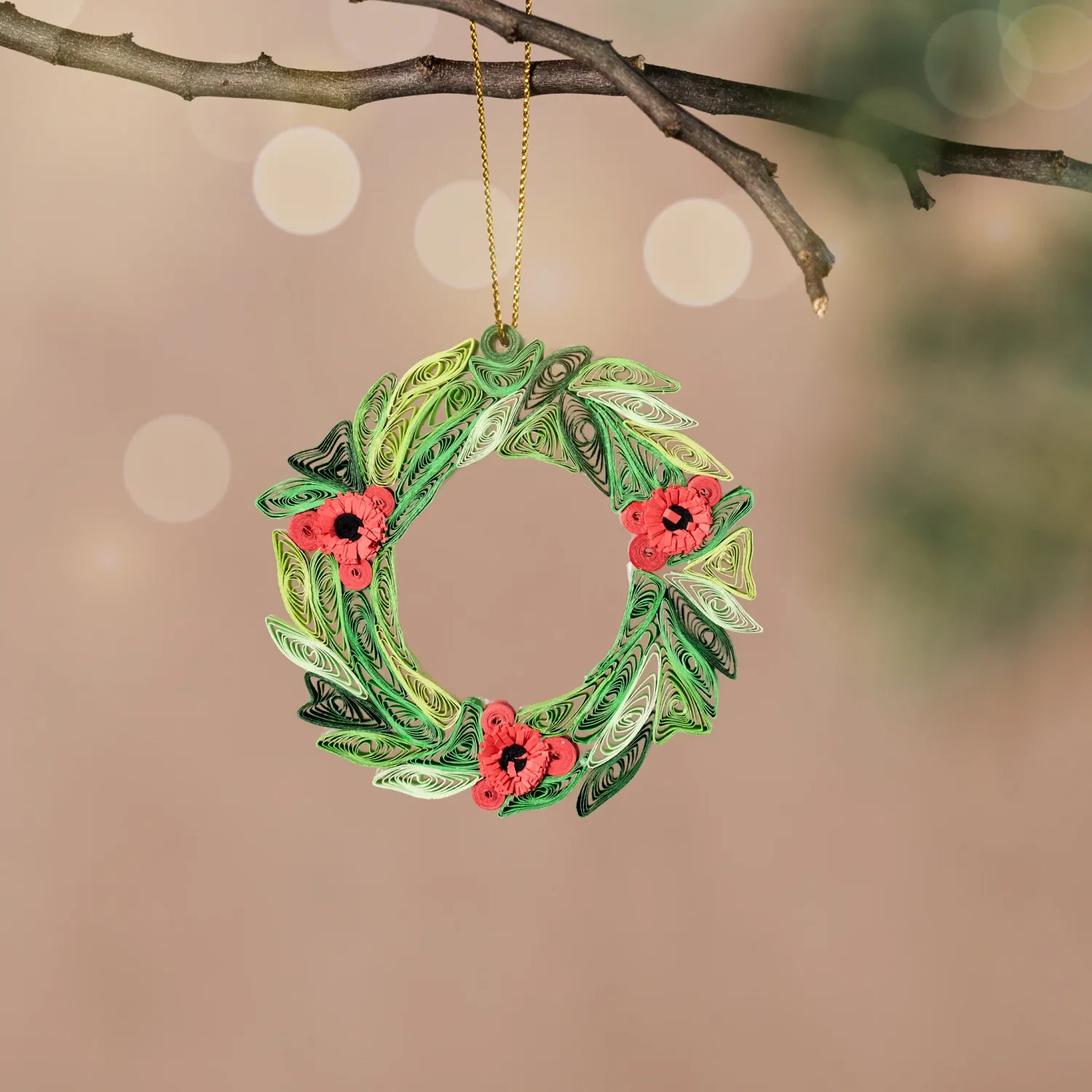 Quilled wreath ornament with shades of green evergreen and red flowers.