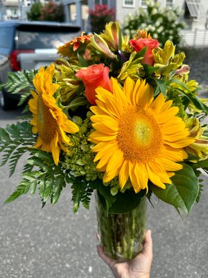A beautiful vase of fresh sunflowers and roses, perfect for a summer vacation or celebration at the Jersey Shore