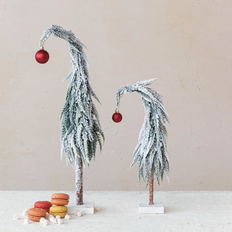 Leaning Evergreen Tree with Red Ball Topper