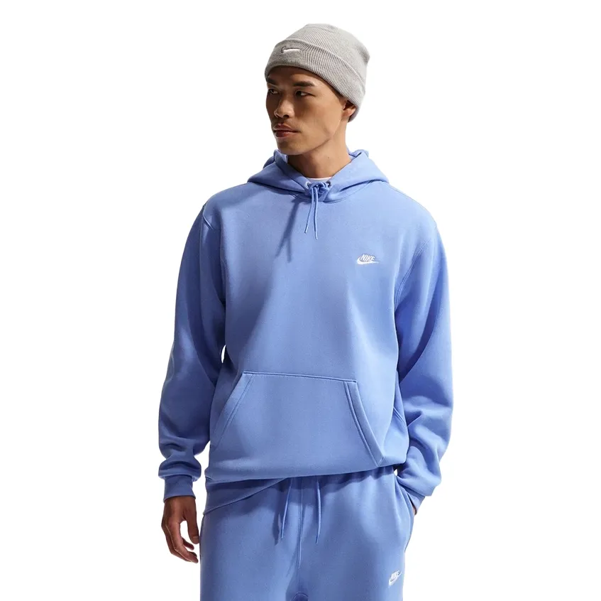 Front three-quarter view of Nike Club Pullover Hoodie in Royal Pulse on model wearing matching joggers and beanie