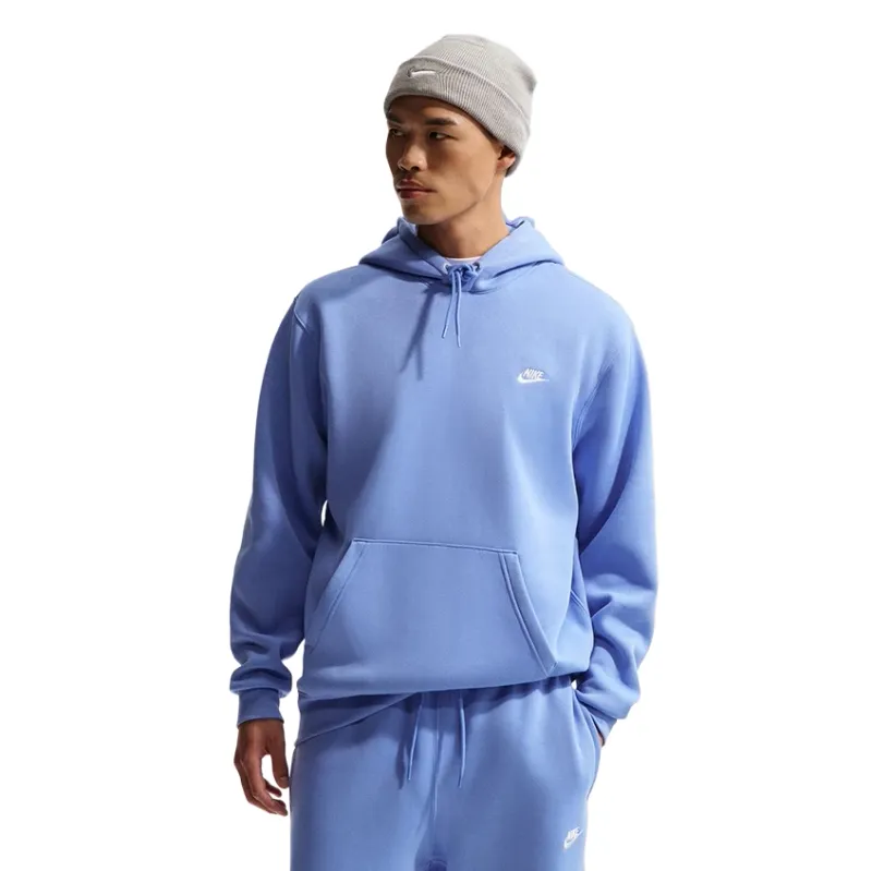 Front three-quarter view of Nike Club Pullover Hoodie in Royal Pulse on model wearing matching joggers and beanie