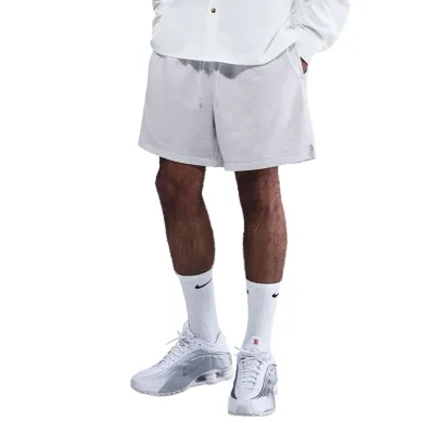 Three-quarter view of model styling birch heather shorts with button-up shirt