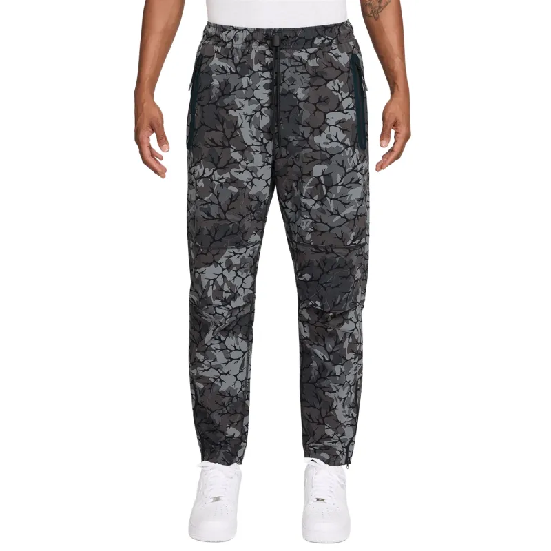 Front view of Nike Tech black print pants showing relaxed fit and elastic waistband