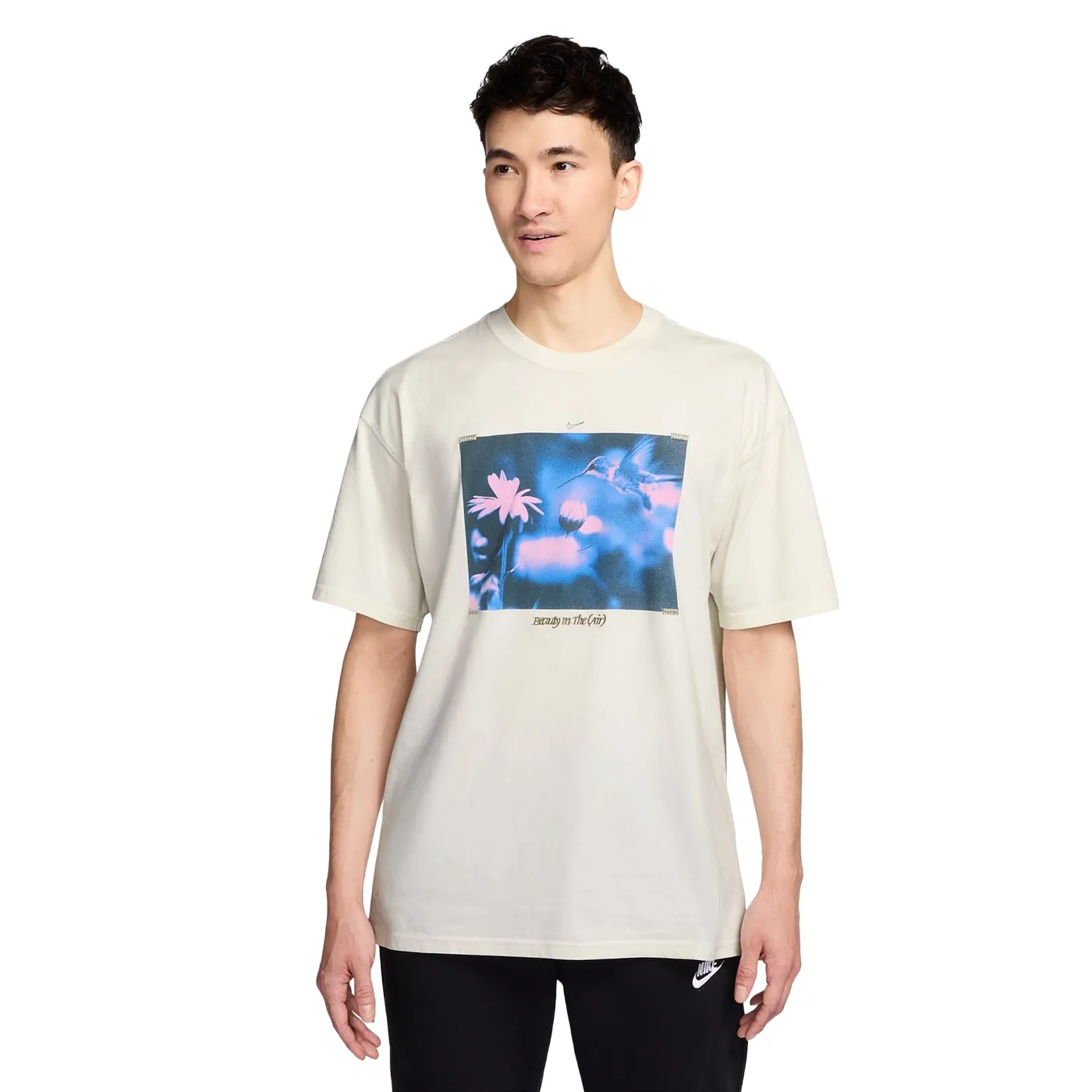 Front view of model wearing phantom Nike tee with floral bird graphic on chest