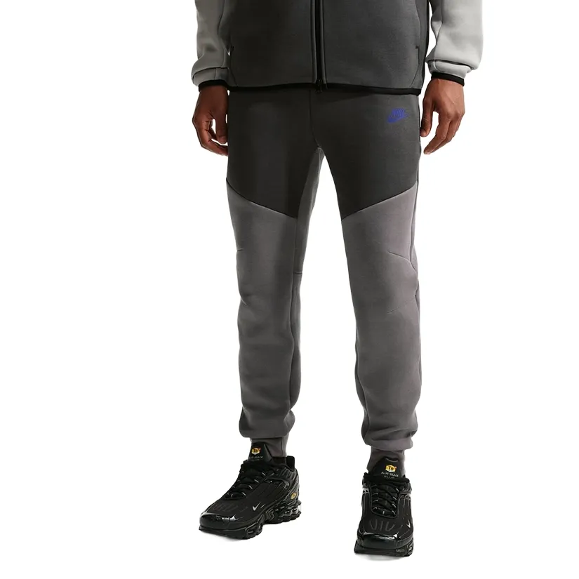 Front view of grey Nike Tech Fleece joggers showing articulated knee panels and tapered fit