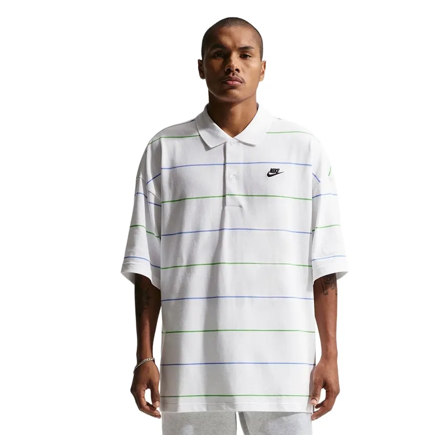 Front view of white striped Nike oversized polo with ribbed collar and embroidered chest logo