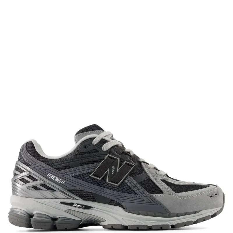Lateral side view of New Balance 1906 sneaker in grey and black with layered mesh upper, suede overlays, and N logo branding.