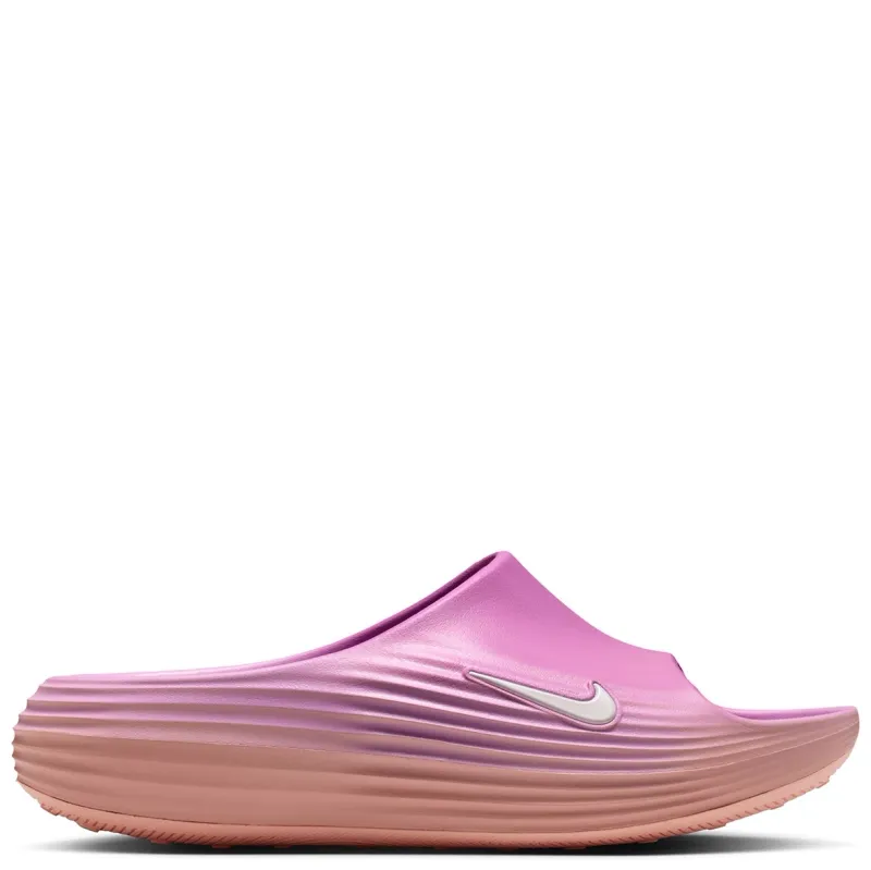 Lateral side view of pink slide featuring white Swoosh and textured ripple foam midsole design