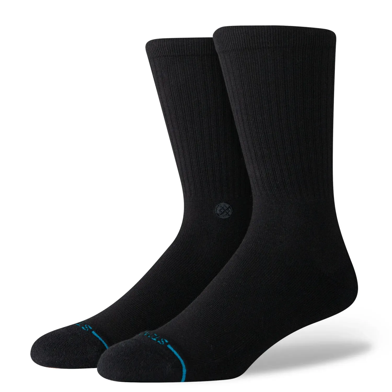 Angled view of black Stance crew socks showing ribbed upper, cushioned footbed, and subtle logo detail on ankle