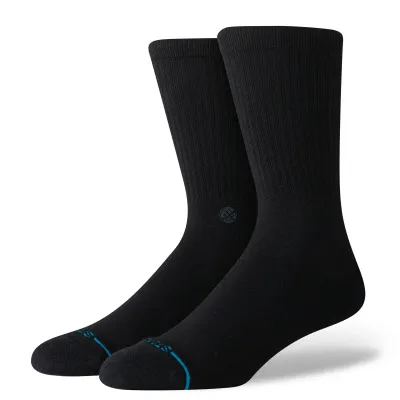 Angled view of black Stance crew socks showing ribbed upper, cushioned footbed, and subtle logo detail on ankle