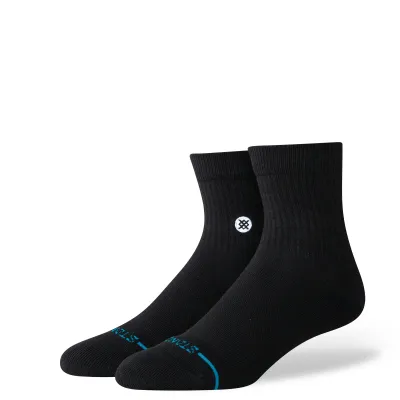 Angled view of black Stance quarter socks showing ribbed cuff, cushioned footbed, and logo detail on ankle