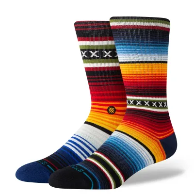 Angled view of Stance crew socks with multicolor striped pattern, featuring red, blue, yellow, and black bands