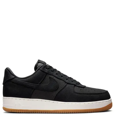 Medial side view of Nike Air Force 1 in black denim with stitched overlays and classic low-top silhouette