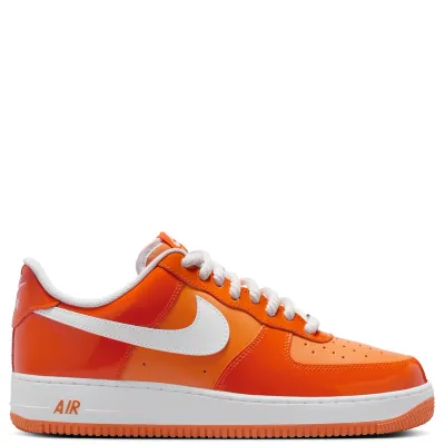 Medial side view with glossy orange panels, tonal stitching, and white midsole contrast