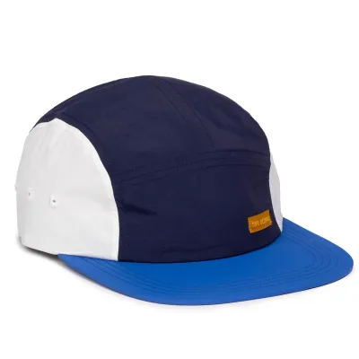 Angled side view of TOPO DESIGNS nylon camp hat with cobalt flat brim and midnight crown
