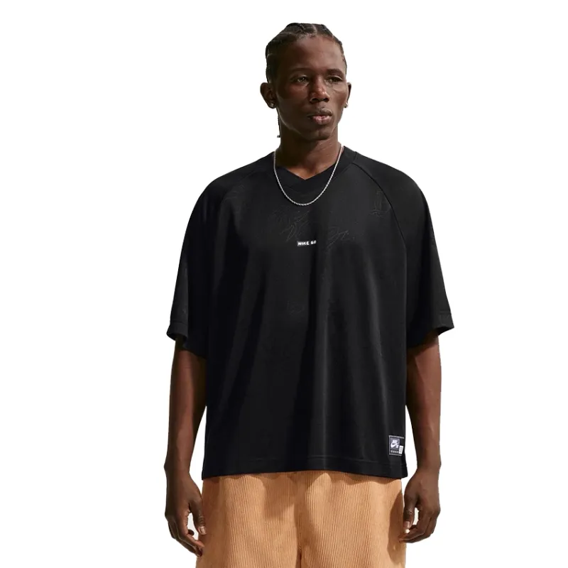Model wearing Nike SB black jacquard jersey with subtle woven doodle graphics