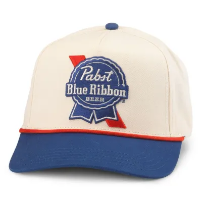 Front view of American Needle Pabst Blue Ribbon Scottie hat in ivory and royal with embroidered beer logo