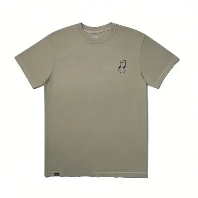 The Quiet Life Music Man Embroidered T-shirt in sage featuring a small embroidered musical note smiley graphic on the left ch