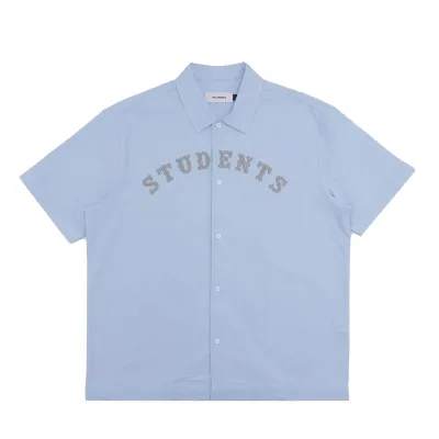 Front view of the Students Golf Crescent Button-Up Shirt in Light Blue with arched Students chest graphic.