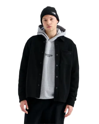 Front view of model wearing The North Face Open Range black fleece shirt layered over a grey hoodie.