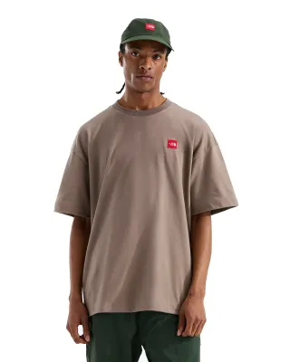 Front view of model wearing The North Face Red Box Tee in Garnet with oversized fit and red chest logo patch.
