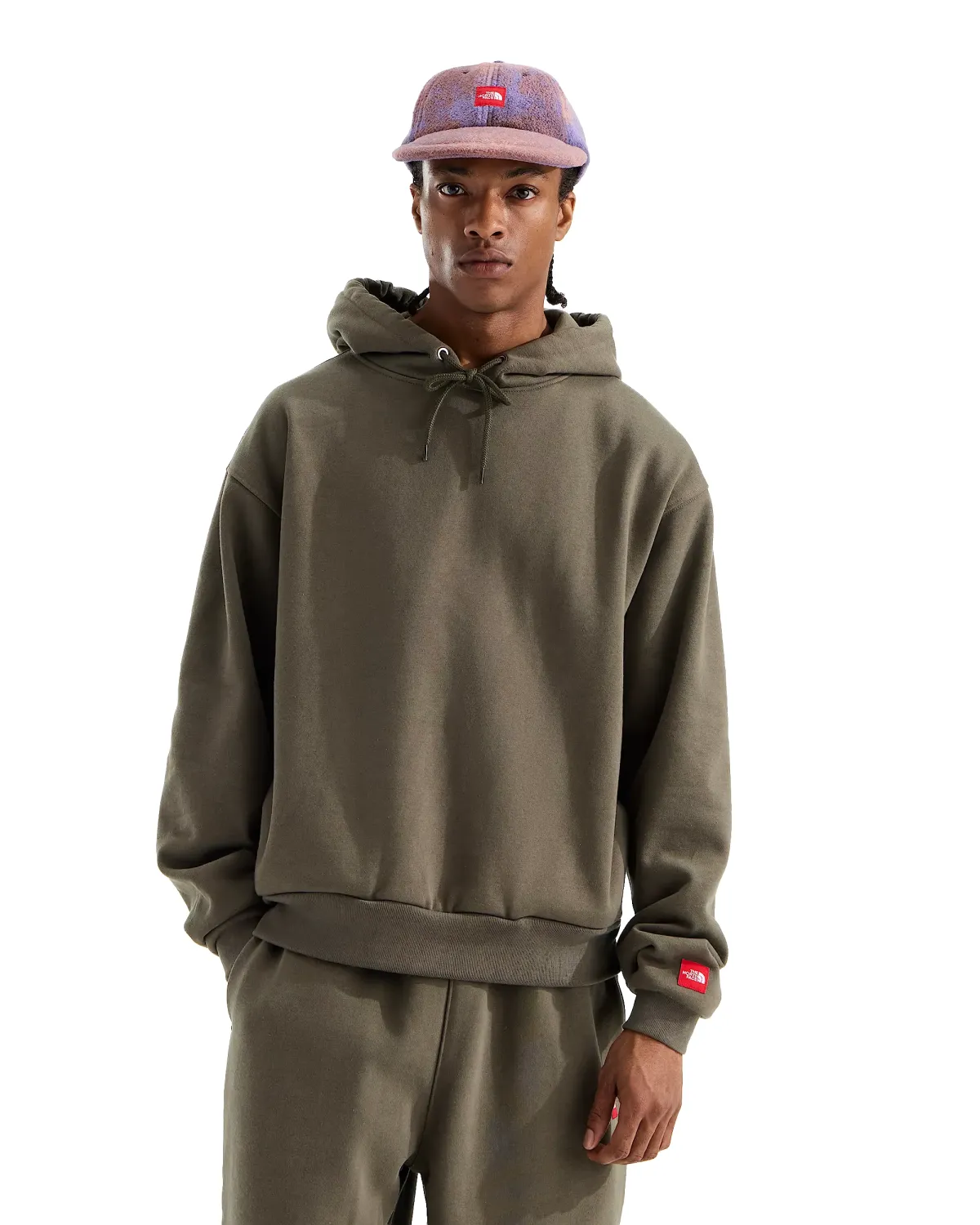 Front view of model wearing The North Face Red Box Hoodie in New Taupe Green with drawcord hood and ribbed trim.