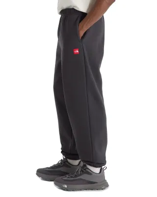 Side view of The North Face Red Box Sweatpants in Obsidian highlighting the hand pocket and red box logo patch.