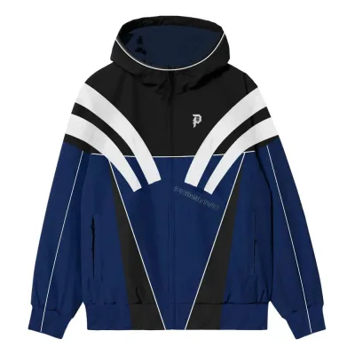 Front view of Primitive Striker Tech Jacket in blue with black and white color blocking, hood, and full-zip closure.