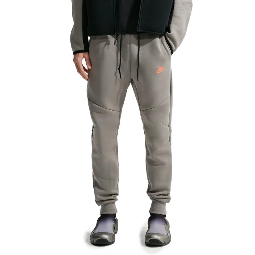 Front view of Light Army Nike Tech Fleece Joggers with articulated seams, black drawcord and orange logo.