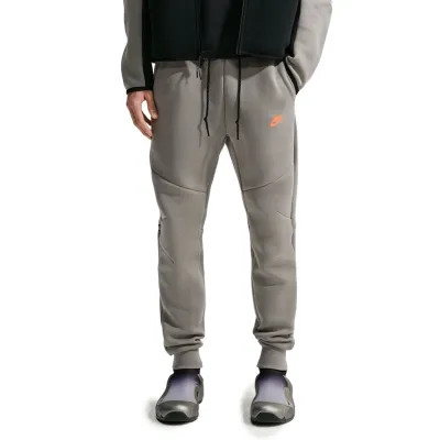 Front view of Light Army Nike Tech Fleece Joggers with articulated seams, black drawcord and orange logo.
