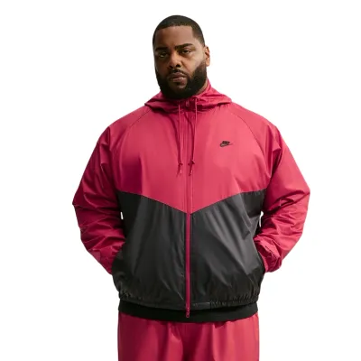 Front view of a model wearing the Tough Red and Black Nike Windrunner Jacket with a roomy layered fit.