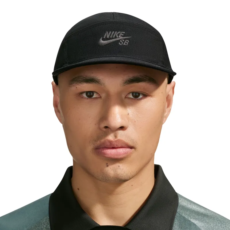 Front view of a model wearing the black Nike SB Fly cap with a low crown and tonal embroidered Nike SB logo.