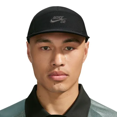 Front view of a model wearing the black Nike SB Fly cap with a low crown and tonal embroidered Nike SB logo.